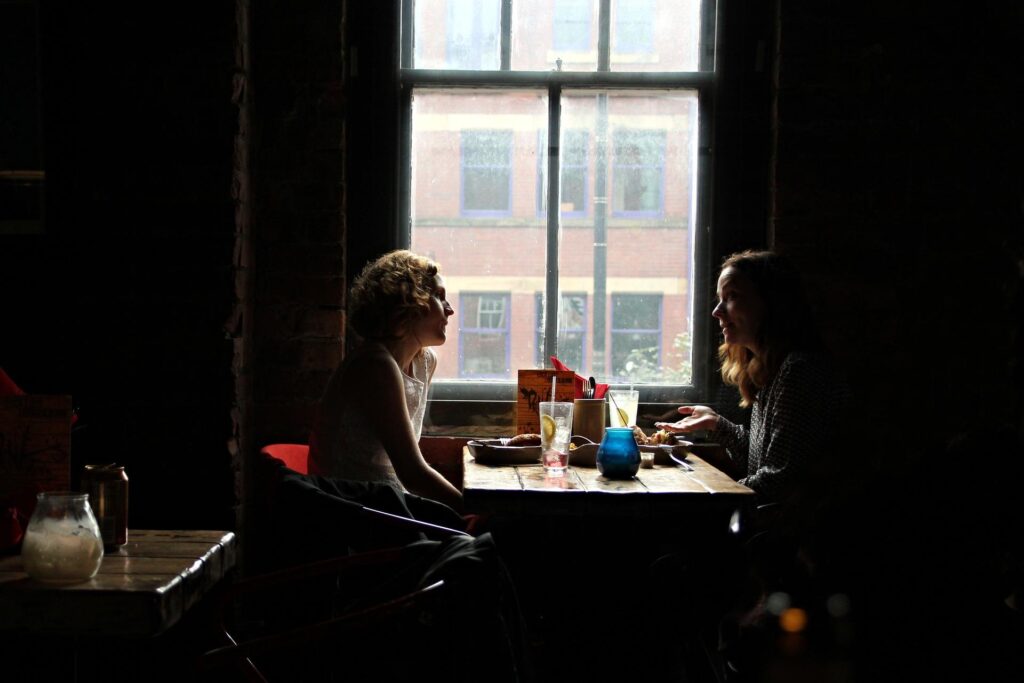 Two people sitting at a table discussing shared work.