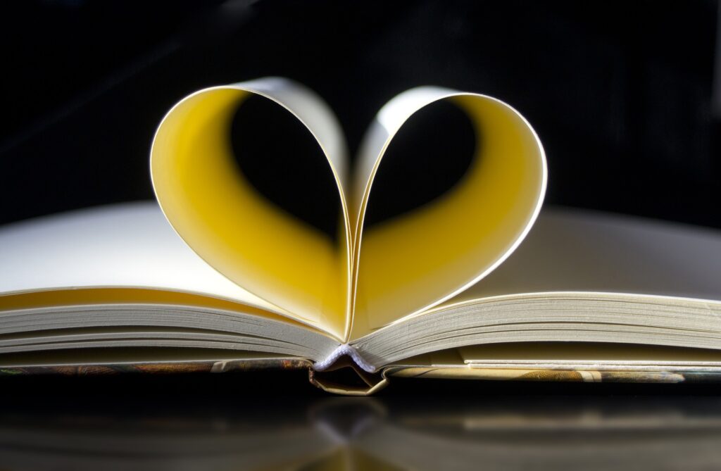 A book with it's pages curled inwards to form the shape of a heart.