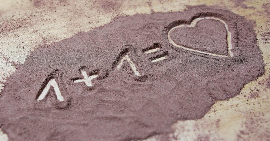 Writing in the sand spelling 1 + 1 is equal to love